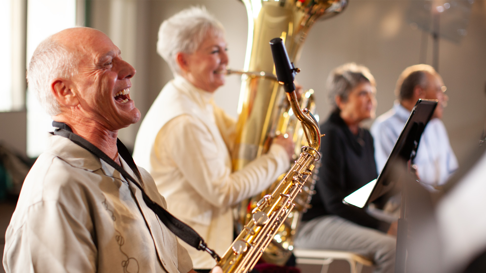 A saxophone player smiling during a New Horizons Band rehearsal at the museum