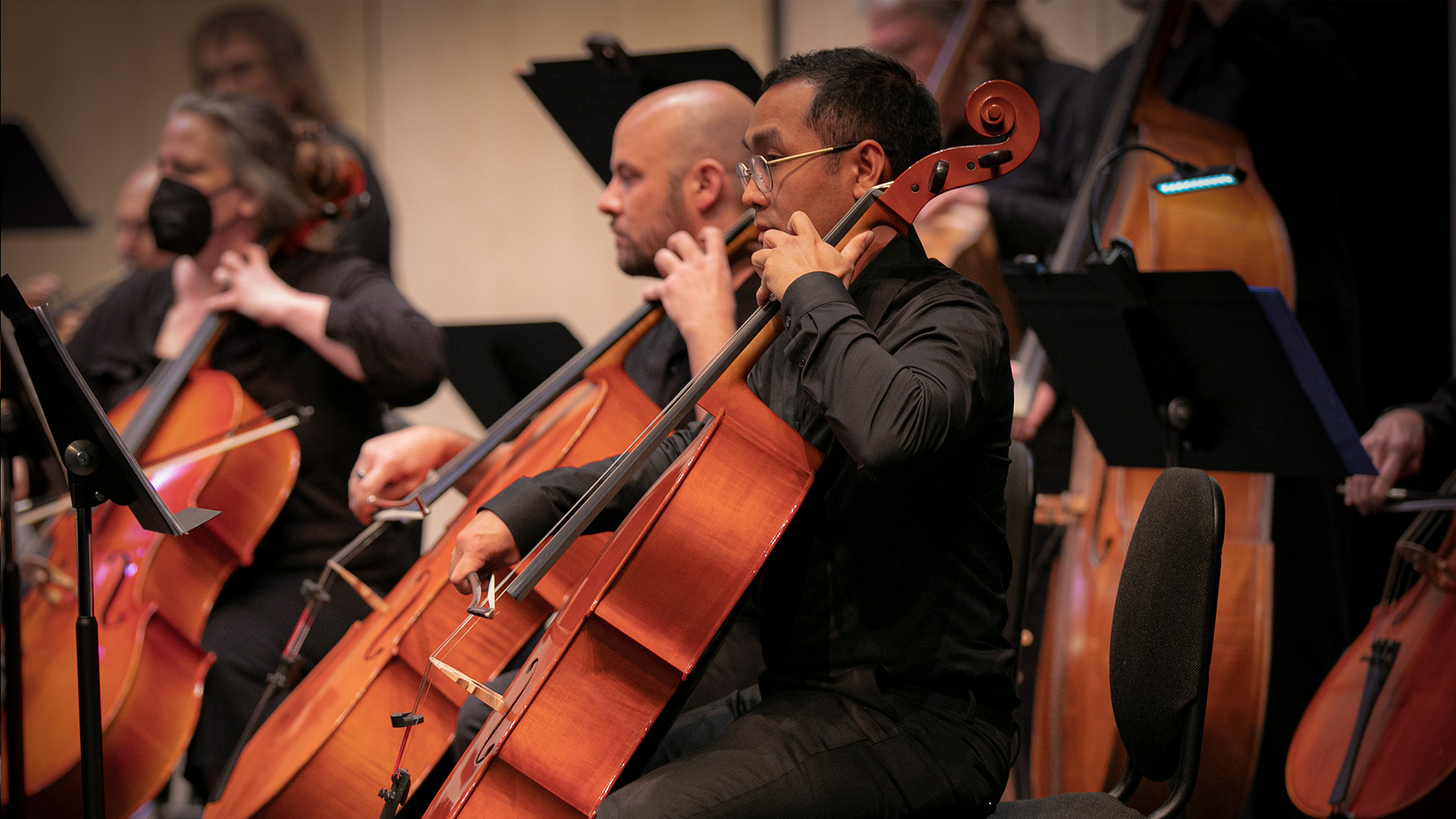 Cellists performing together during an adult string orchestra rehearsal at the museum