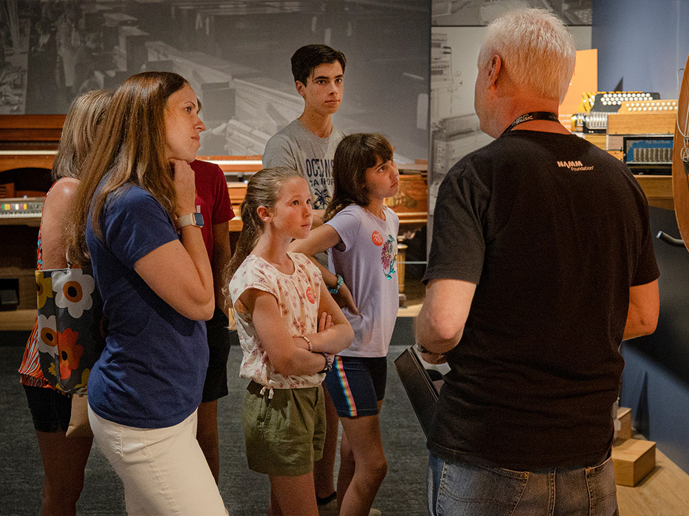 A museum volunteer talking with a family in the galleries at the Museum of Making Music