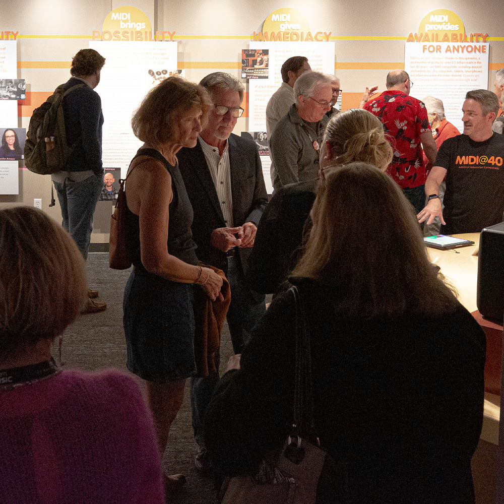 Guests talking in front of exhibition panels during an opening reception at the museum