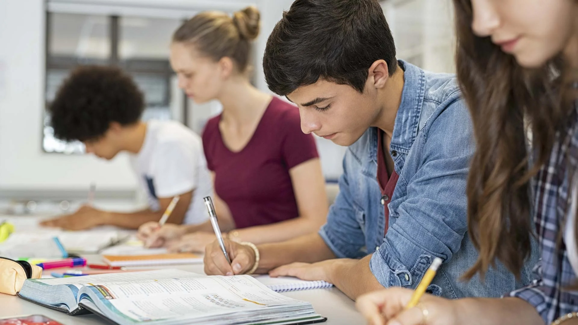 High school students working at a classroom table, the audience for these secondary music lesson plans