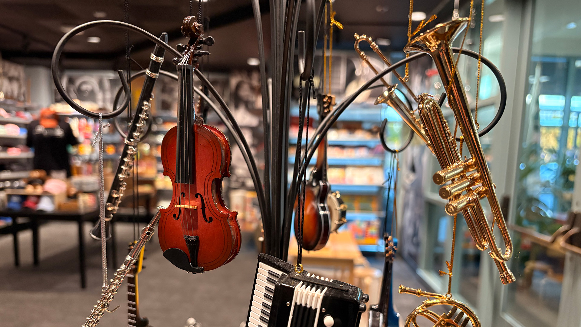 Miniature violin, trumpet, accordion and flute ornaments on display in the Museum Store